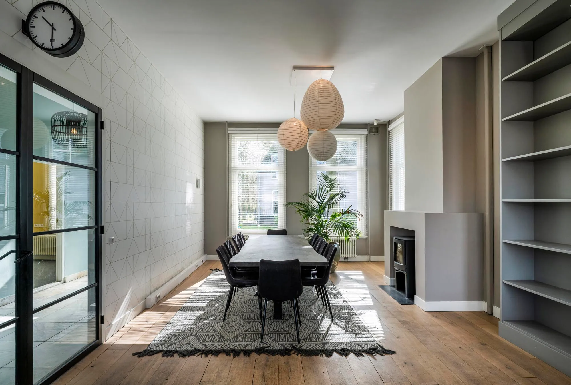 Een lichte kamer in de Pastorie met grote ramen en een lange tafel